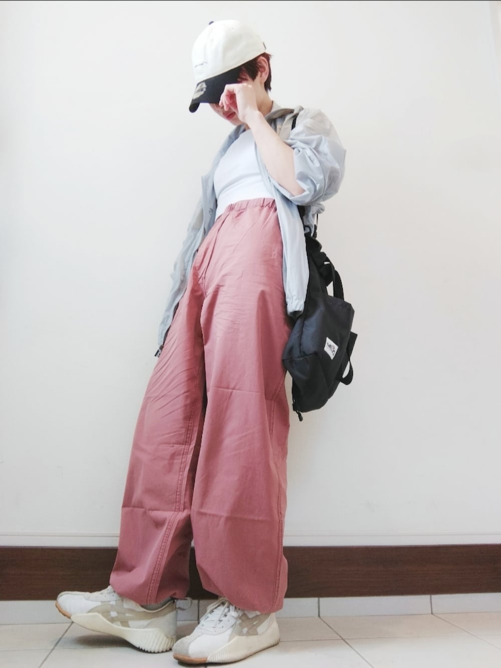 グレー系のブルゾン、パープル系のカーゴパンツ、ベージュ系のスニーカーを着用したレディースの春コーディネートの2枚目の写真