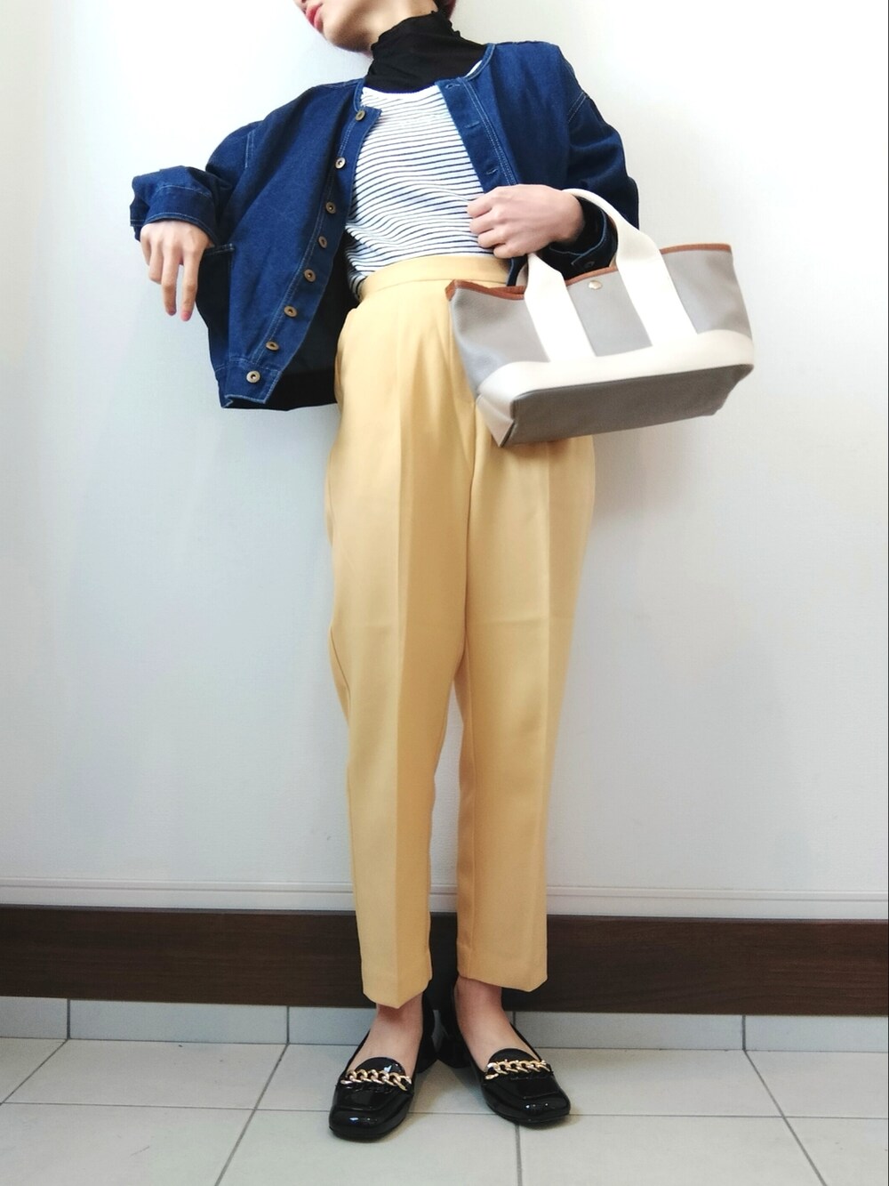 イエロー系のスラックス、ホワイト系のTシャツ/カットソー、ブルー系のブルゾンを着用したレディースの春コーディネートの2枚目の写真