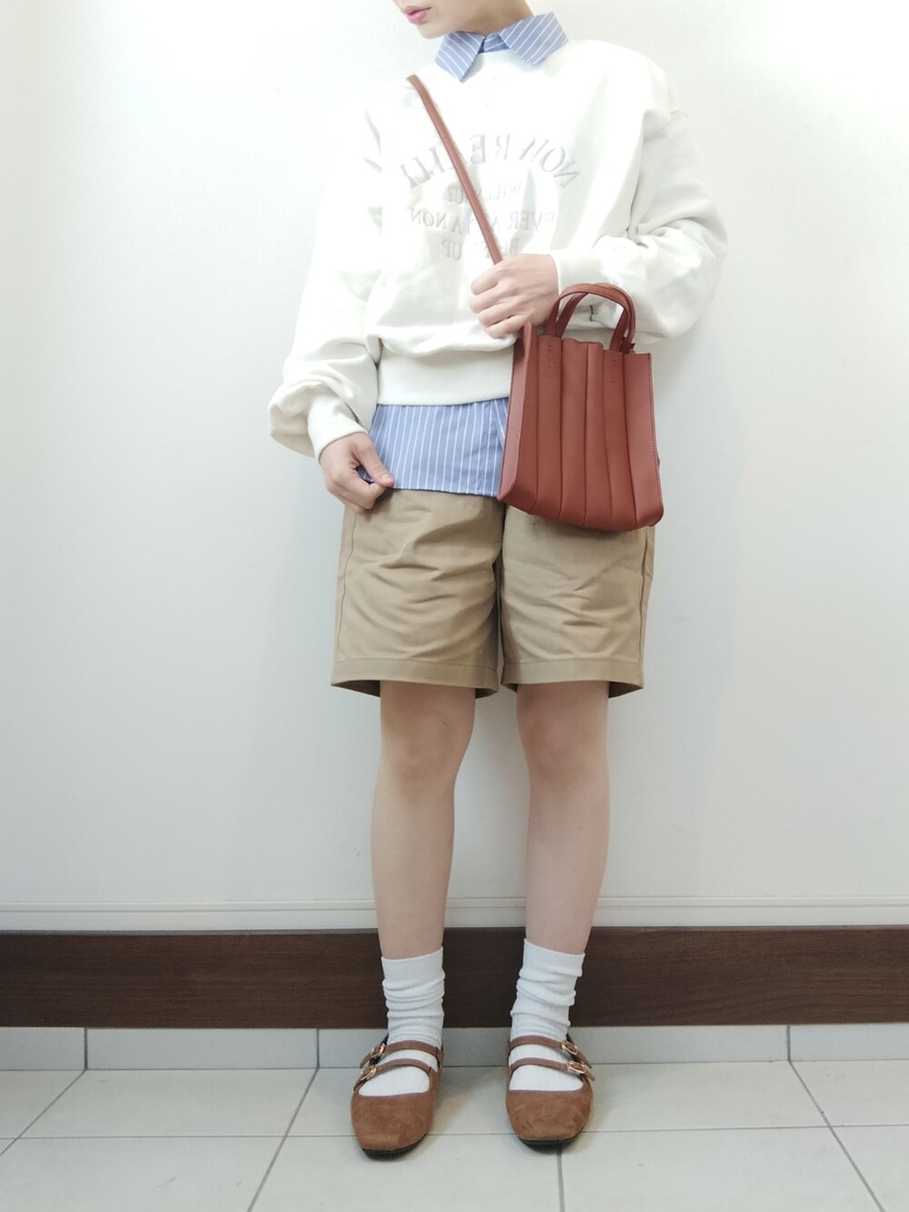 ホワイト系のスウェット、ベージュ系のトートバッグ、ブルー系のシャツ/ブラウスを着用したレディースの春コーディネートの2枚目の写真