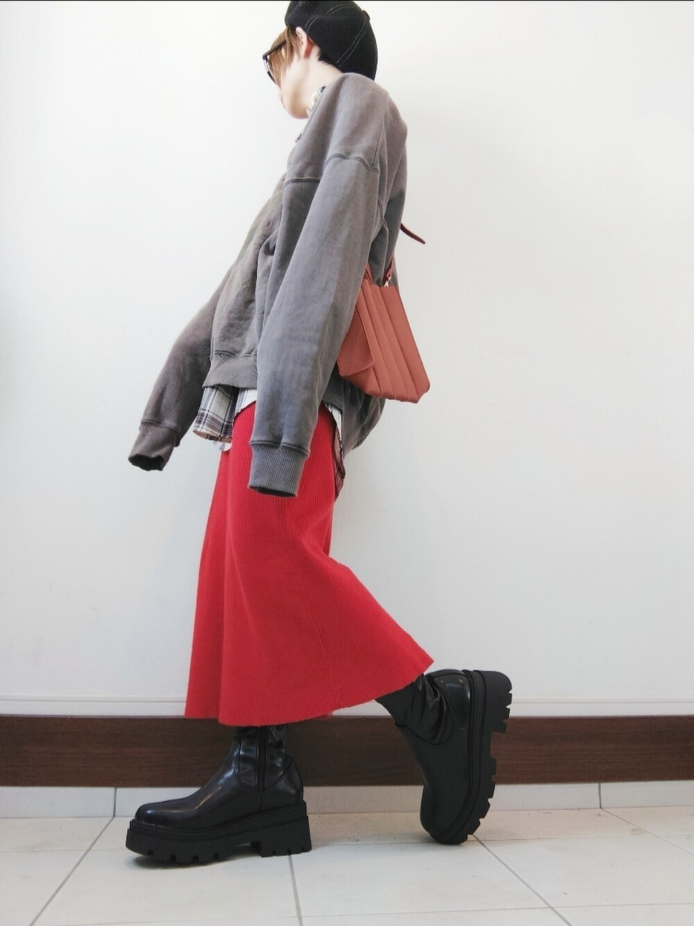ベージュ系のトートバッグ、ブラウン系のスウェット、レッド系のスカートを着用したレディースの秋コーディネートの2枚目の写真