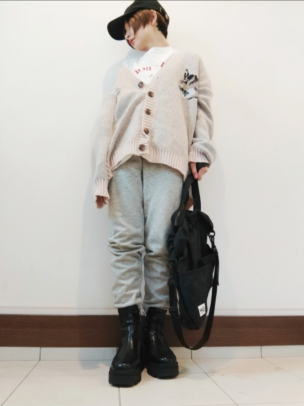 ブラック系のショルダーバッグ、グレー系のスウェットパンツ、ブラック系のブーツを着用したレディースの秋コーディネートの2枚目の写真