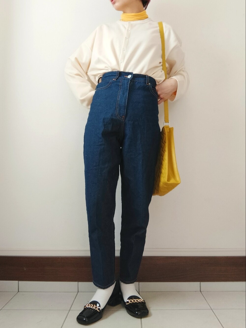 ホワイト系のカーディガン/ボレロ、イエロー系のショルダーバッグ、ブルー系のデニムパンツを着用したレディースの春コーディネートの2枚目の写真