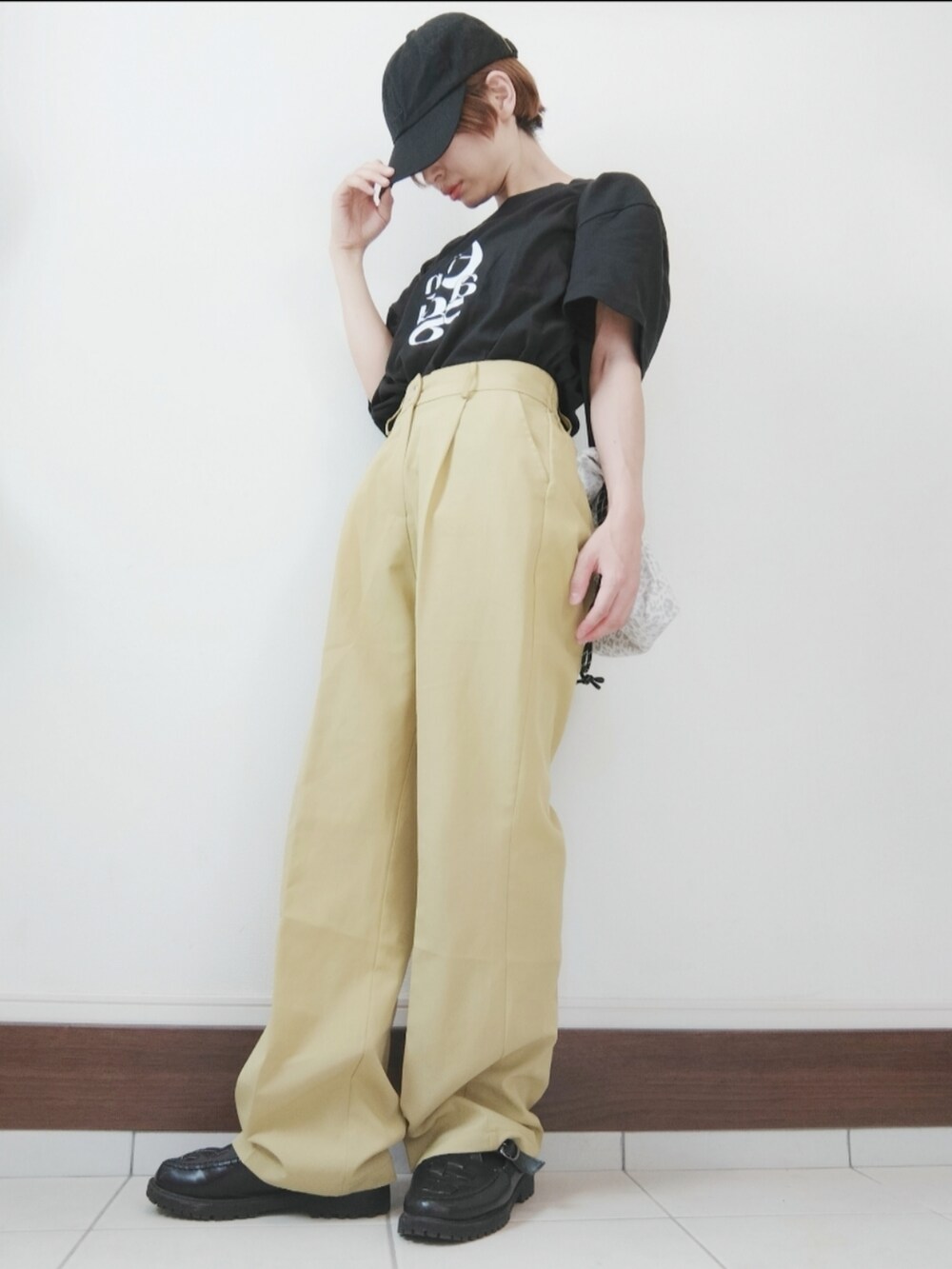 ブラック系のTシャツ/カットソー、イエロー系のスラックス、ブラック系のサンダルを着用したレディースの秋コーディネートの2枚目の写真
