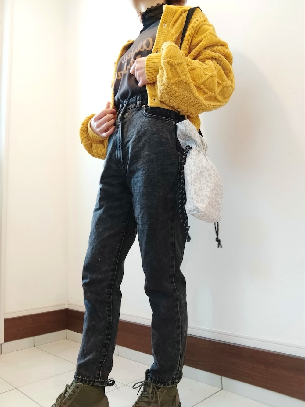 グレー系のTシャツ/カットソー、イエロー系のカーディガン/ボレロ、ブラック系のデニムパンツを着用したレディースの冬コーディネートの2枚目の写真