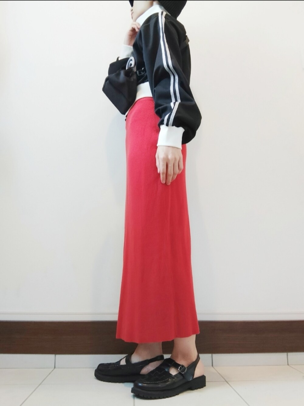 ブラック系のジャージ、ブラック系のショルダーバッグ、レッド系のスカートを着用したレディースの秋コーディネートの2枚目の写真