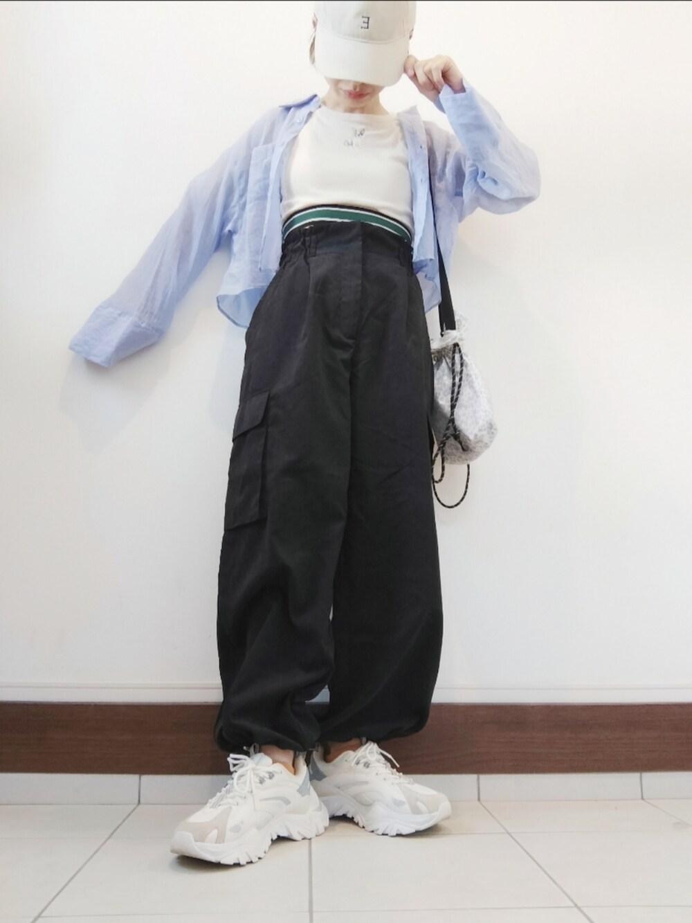 ブラック系のカーゴパンツ、ホワイト系のスニーカー、ブルー系のシャツ/ブラウスを着用したレディースの秋コーディネートの2枚目の写真