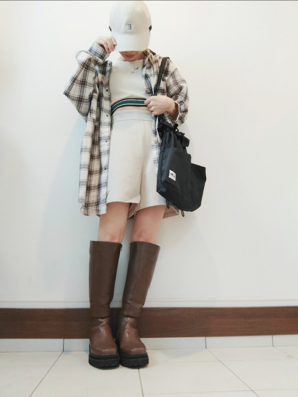 ホワイト系のその他パンツ、ベージュ系のタンクトップ、ブラウン系のブーツを着用したレディースの秋コーディネートの2枚目の写真