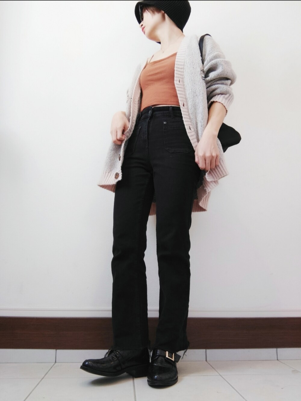 ブラック系のショルダーバッグ、ブラック系のデニムパンツ、ブラック系のローファーを着用したレディースの秋コーディネートの2枚目の写真