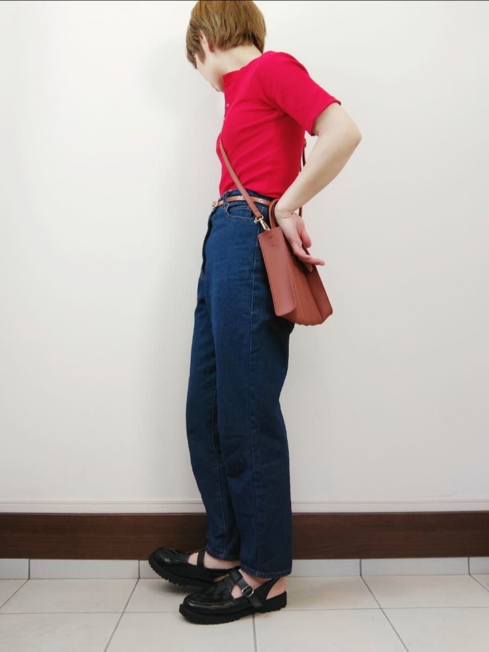 レッド系のTシャツ/カットソー、ベージュ系のトートバッグ、ブルー系のデニムパンツを着用したレディースの春コーディネートの2枚目の写真