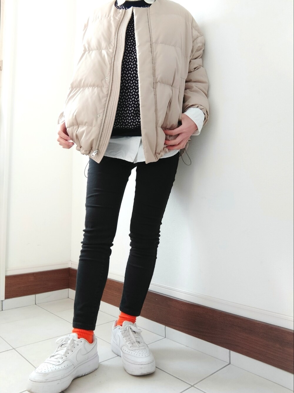 ベージュ系のダウンジャケット/コート、ブルー系のニット/セーター、イエロー系のショルダーバッグを着用したレディースの冬コーディネートの2枚目の写真