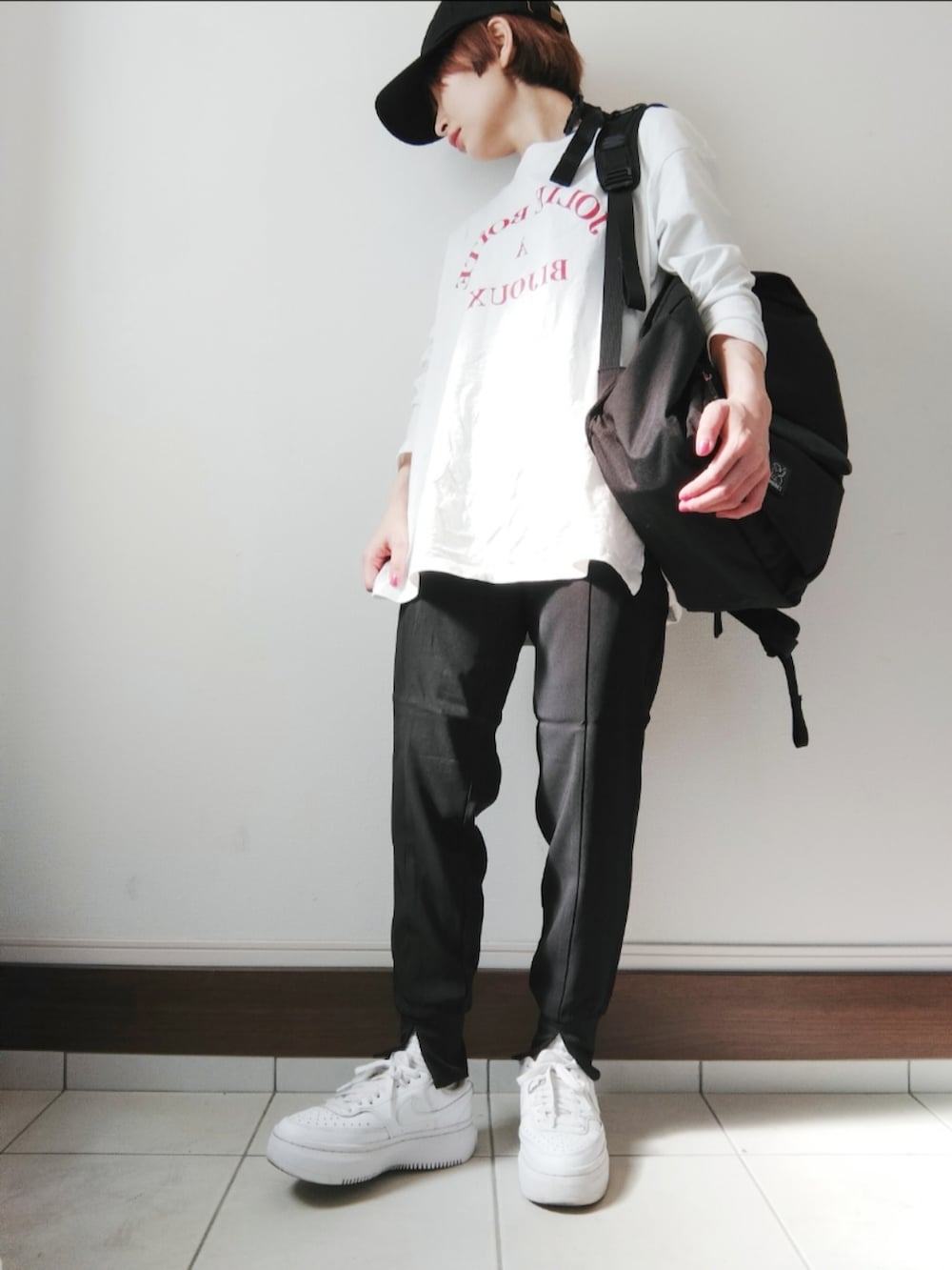 ブラック系のその他パンツ、ブラック系のバックパック/リュック、ホワイト系のスニーカーを着用したレディースの春コーディネートの2枚目の写真