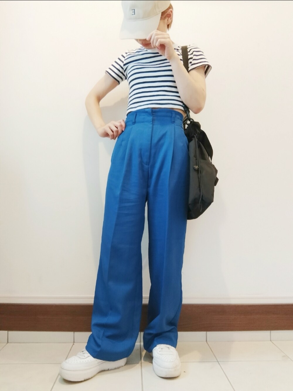 ブラック系のショルダーバッグ、ブルー系のスラックス、ブルー系のTシャツ/カットソーを着用したレディースの夏コーディネートの2枚目の写真