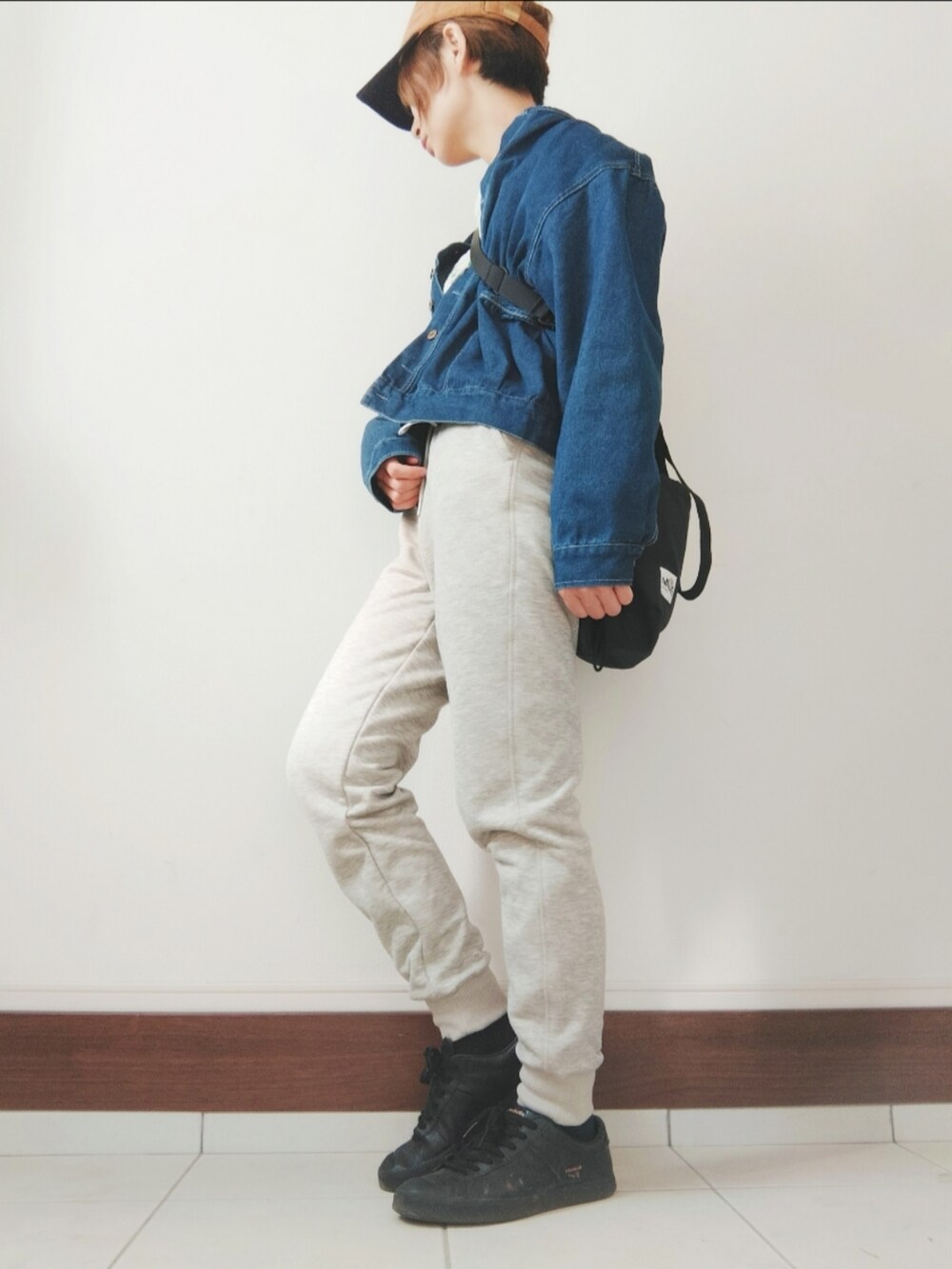 ブルー系のブルゾン、グレー系のスウェットパンツ、ブラック系のスニーカーを着用したレディースの秋コーディネートの2枚目の写真