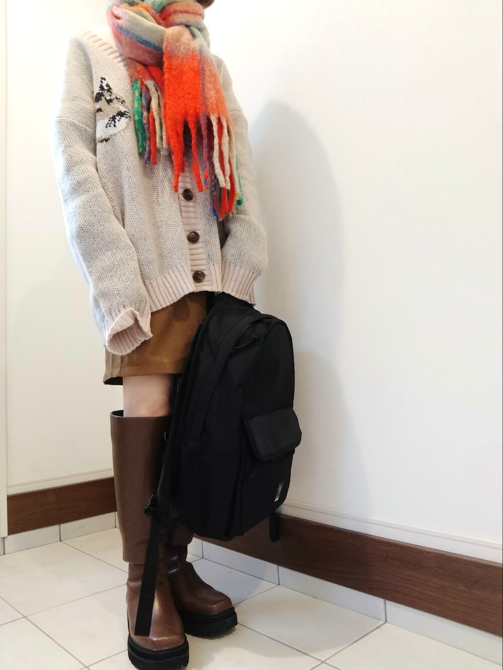 ベージュ系のカーディガン/ボレロ、イエロー系のその他パンツ、ブラウン系のブーツを着用したレディースの冬コーディネートの2枚目の写真