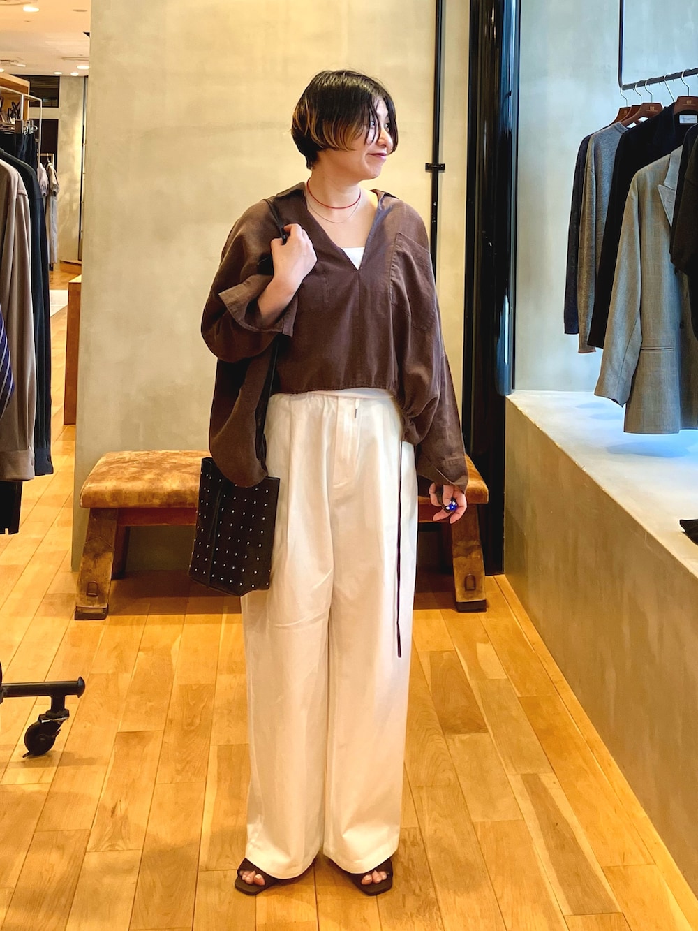 ホワイト系のその他パンツ、ブラウン系のシャツ/ブラウス、ブラウン系のサンダルを着用したレディースの春コーディネートの2枚目の写真