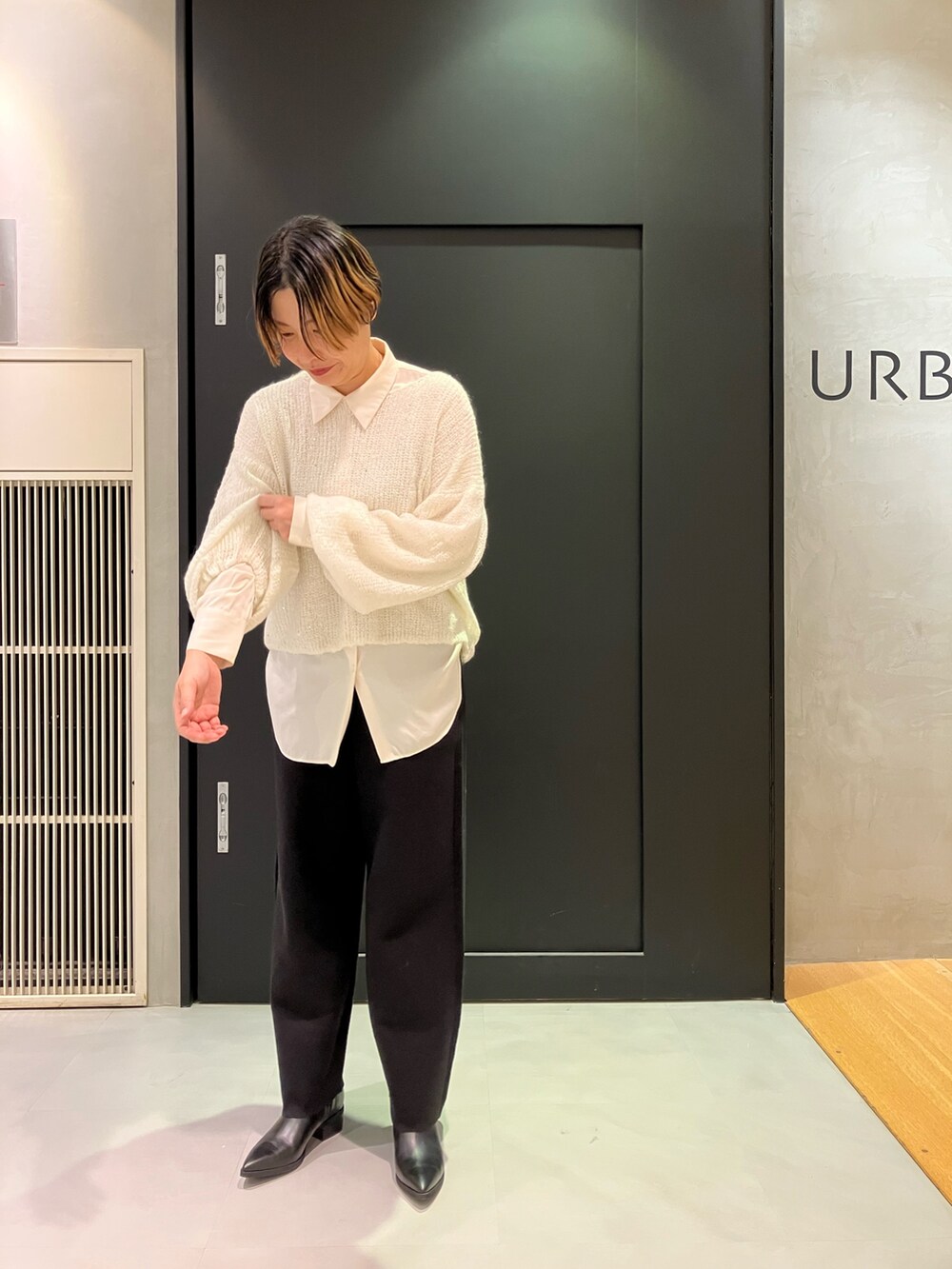 ブラック系のブーツ、ホワイト系のTシャツ/カットソー、ブラック系のチェスターコートを着用したレディースの秋コーディネートの6枚目の写真