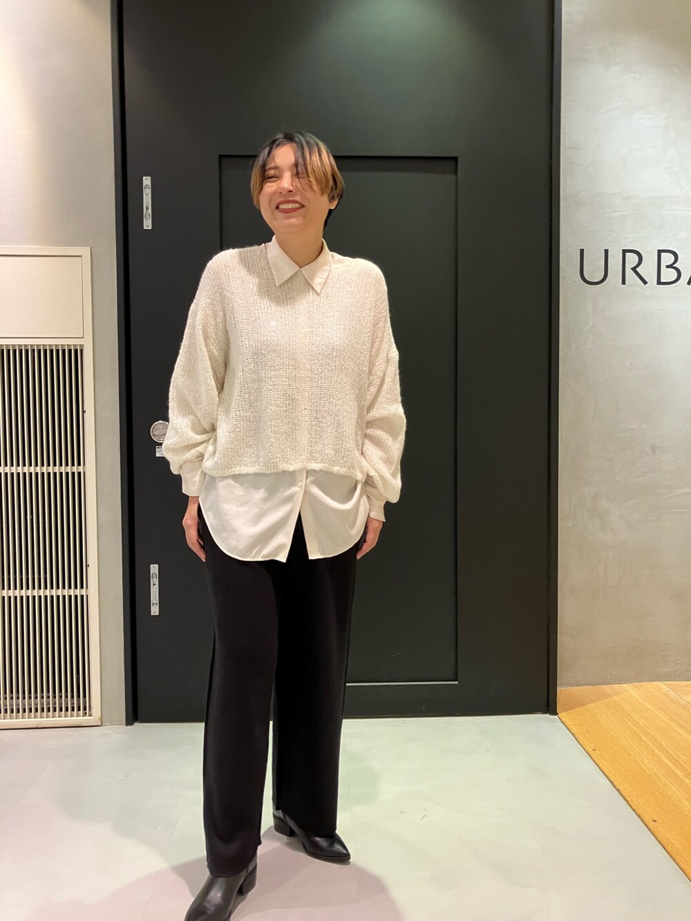 ブラック系のブーツ、ホワイト系のTシャツ/カットソー、ブラック系のチェスターコートを着用したレディースの秋コーディネートの5枚目の写真