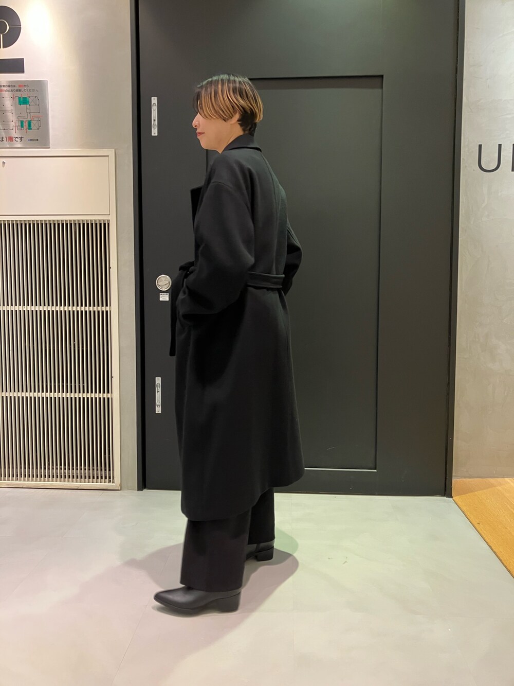 ブラック系のブーツ、ホワイト系のTシャツ/カットソー、ブラック系のチェスターコートを着用したレディースの秋コーディネートの3枚目の写真