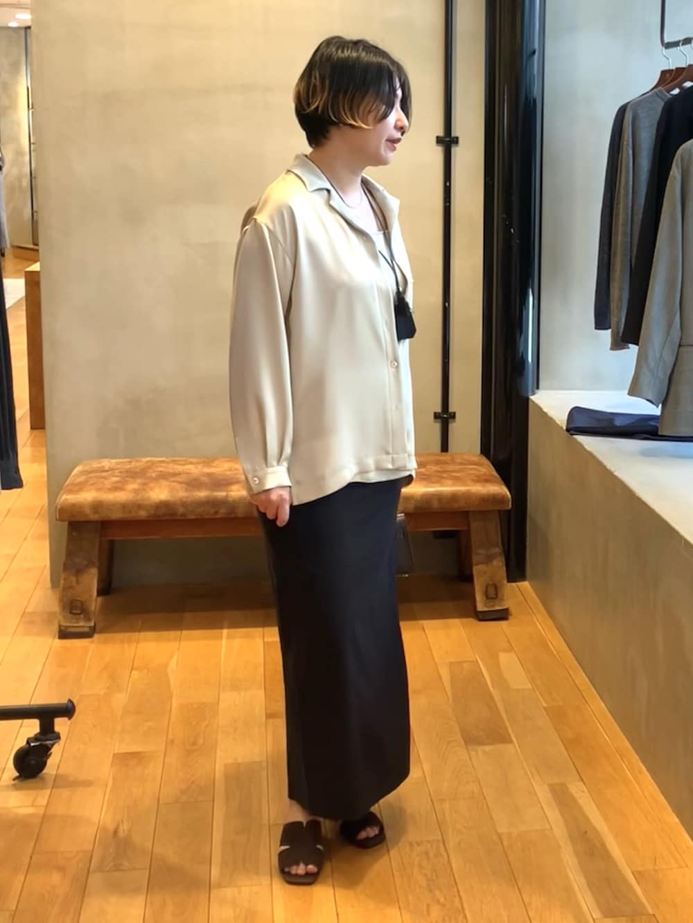 ベージュ系のシャツ/ブラウス、ブラック系のスカート、ブラウン系のサンダルを着用したレディースの春コーディネートの2枚目の写真