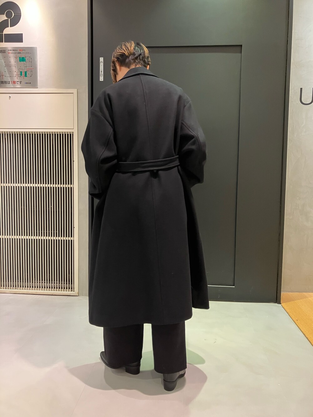 ブラック系のブーツ、ホワイト系のTシャツ/カットソー、ブラック系のチェスターコートを着用したレディースの秋コーディネートの4枚目の写真