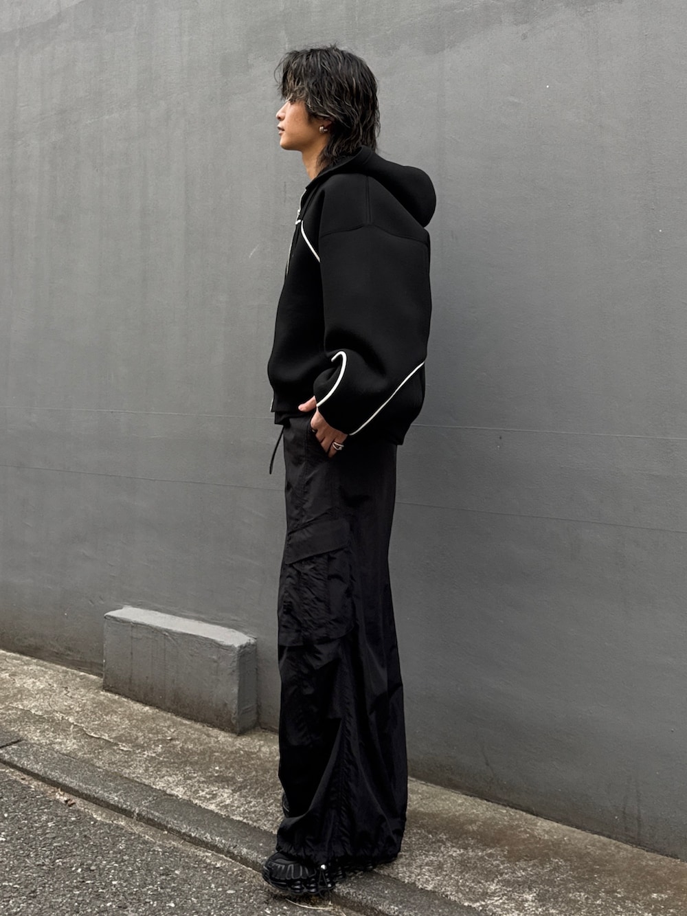 ブラック系のパーカー、ブラック系のカーゴパンツ、ブラック系のスウェットを着用したメンズの冬コーディネートの2枚目の写真