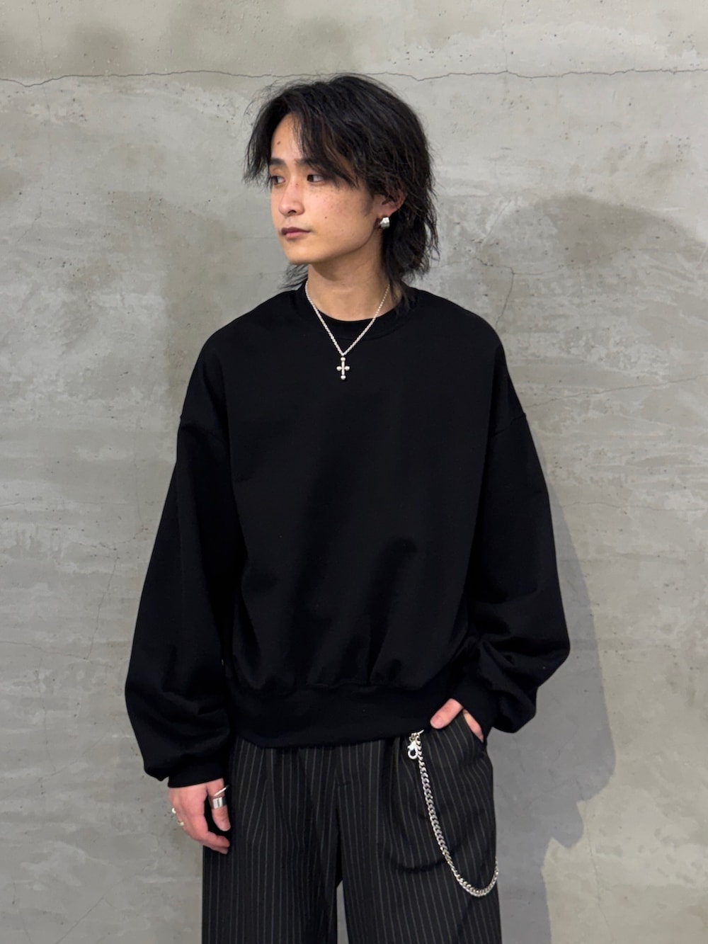 ブラック系のスウェット、ブラック系のスラックス、シルバー系のウォレットチェーンを着用したメンズの春コーディネートの4枚目の写真
