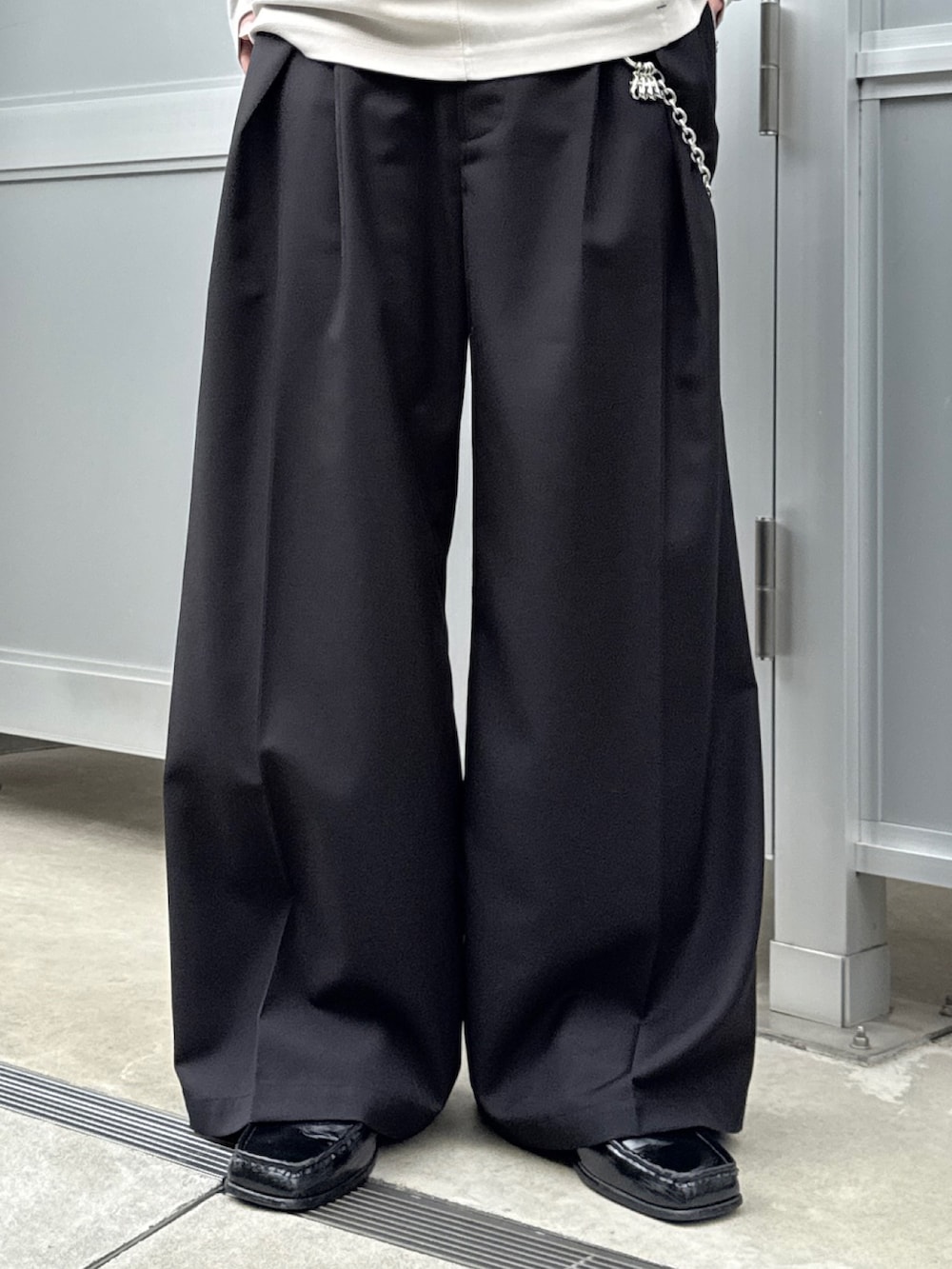 グレー系のTシャツ/カットソー、ブラック系のショルダーバッグ、ブラック系のスラックスを着用したメンズの春コーディネートの6枚目の写真