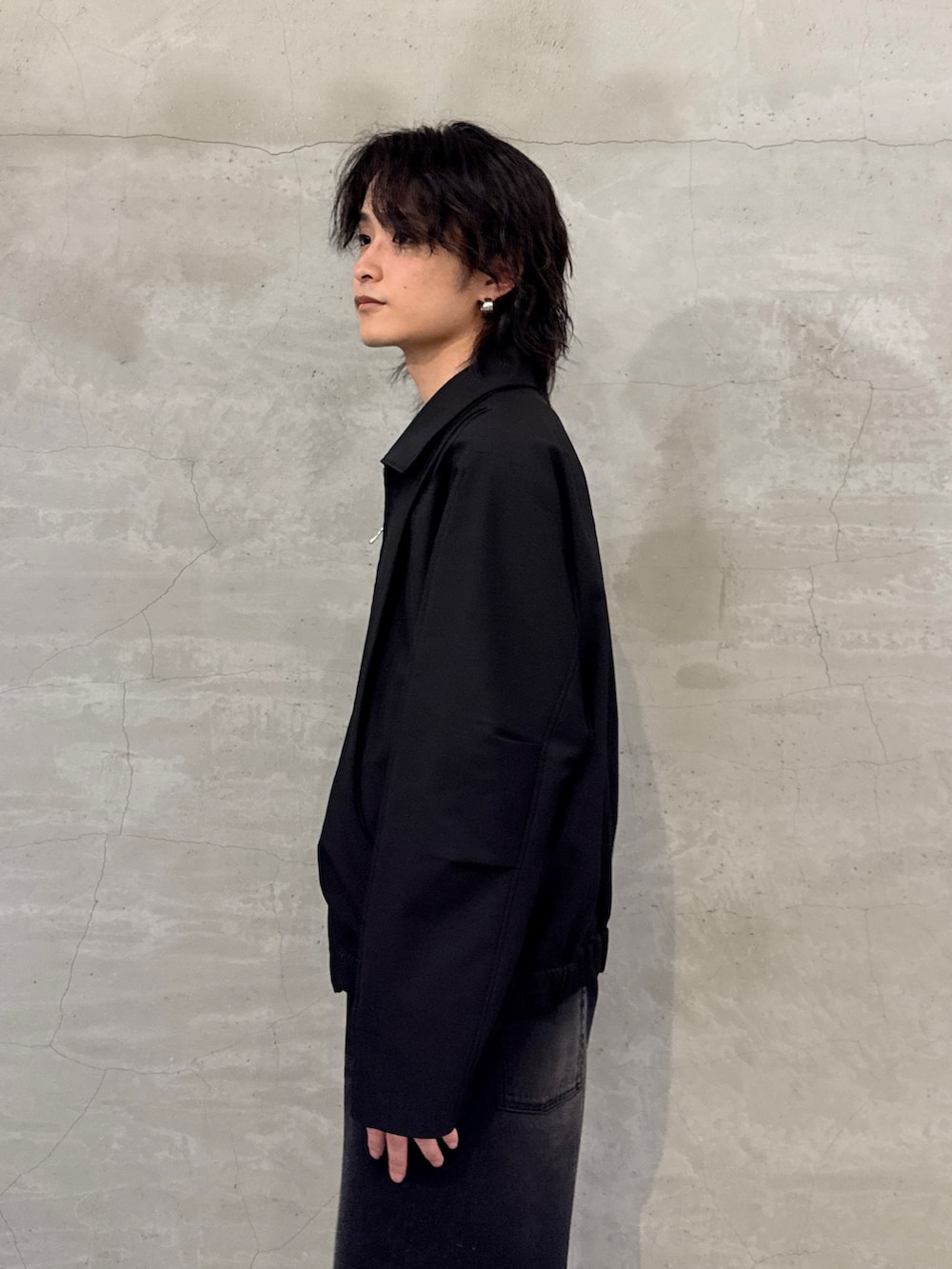 ブラック系のブルゾン、ブラック系のデニムパンツを着用したメンズの春コーディネートの5枚目の写真