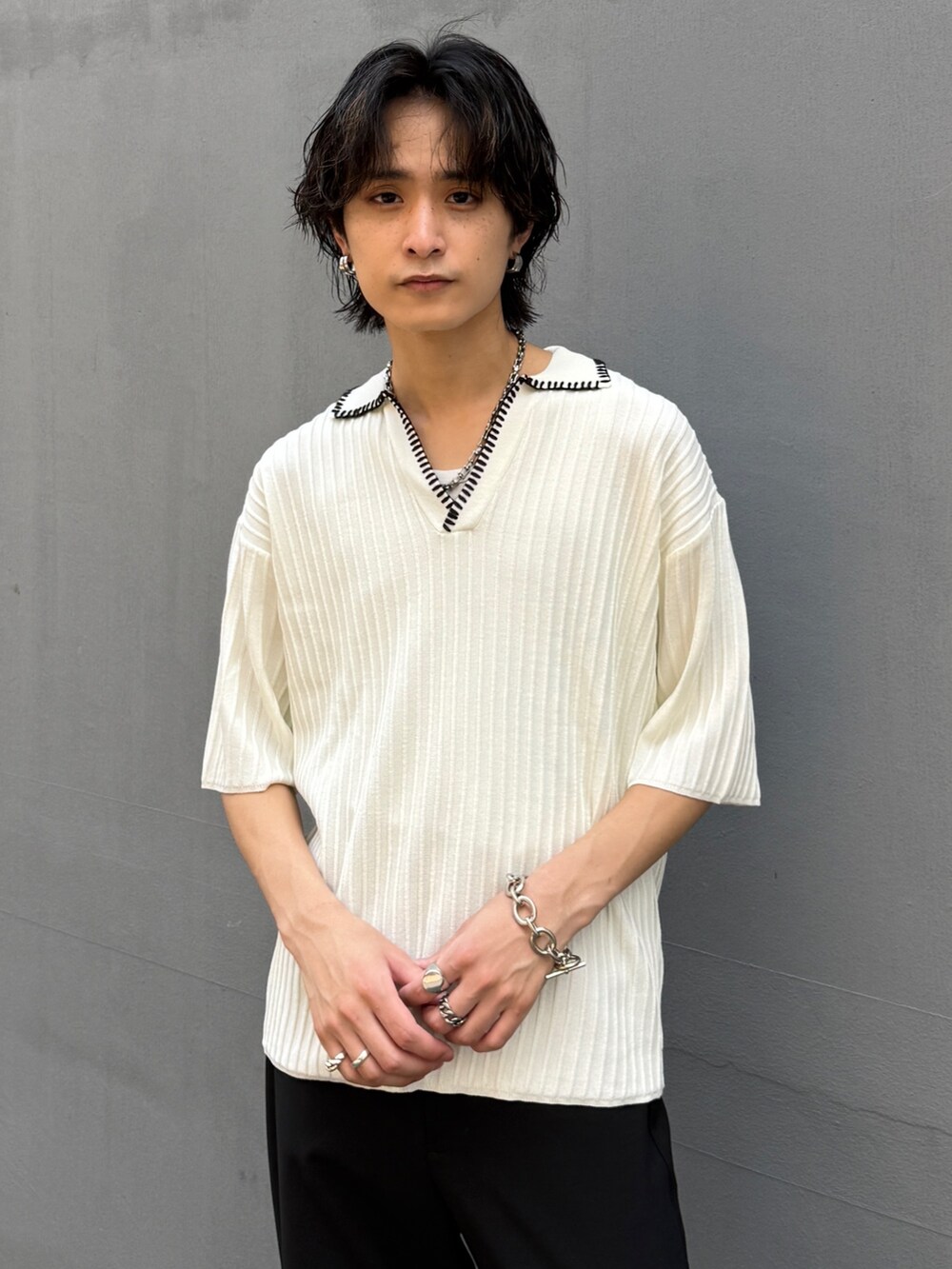 ホワイト系のニット/セーター、ブラック系のスラックスを着用したメンズの夏コーディネートの4枚目の写真