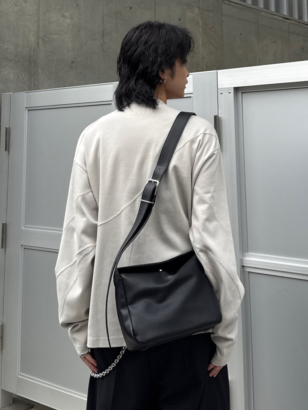 グレー系のTシャツ/カットソー、ブラック系のショルダーバッグ、ブラック系のスラックスを着用したメンズの春コーディネートの5枚目の写真