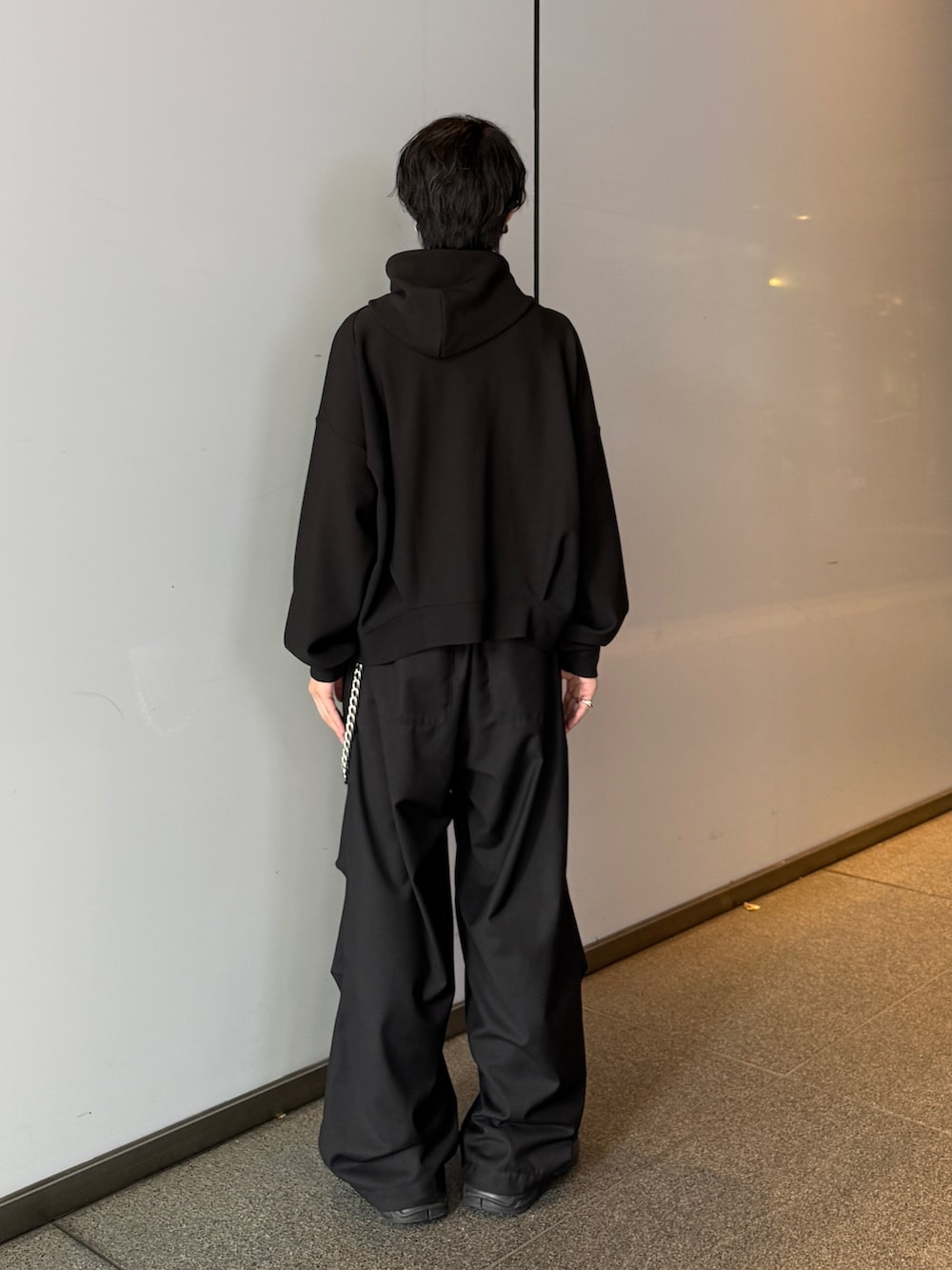 ブラック系のパーカー、ブラック系のスラックスを着用したメンズの秋コーディネートの4枚目の写真