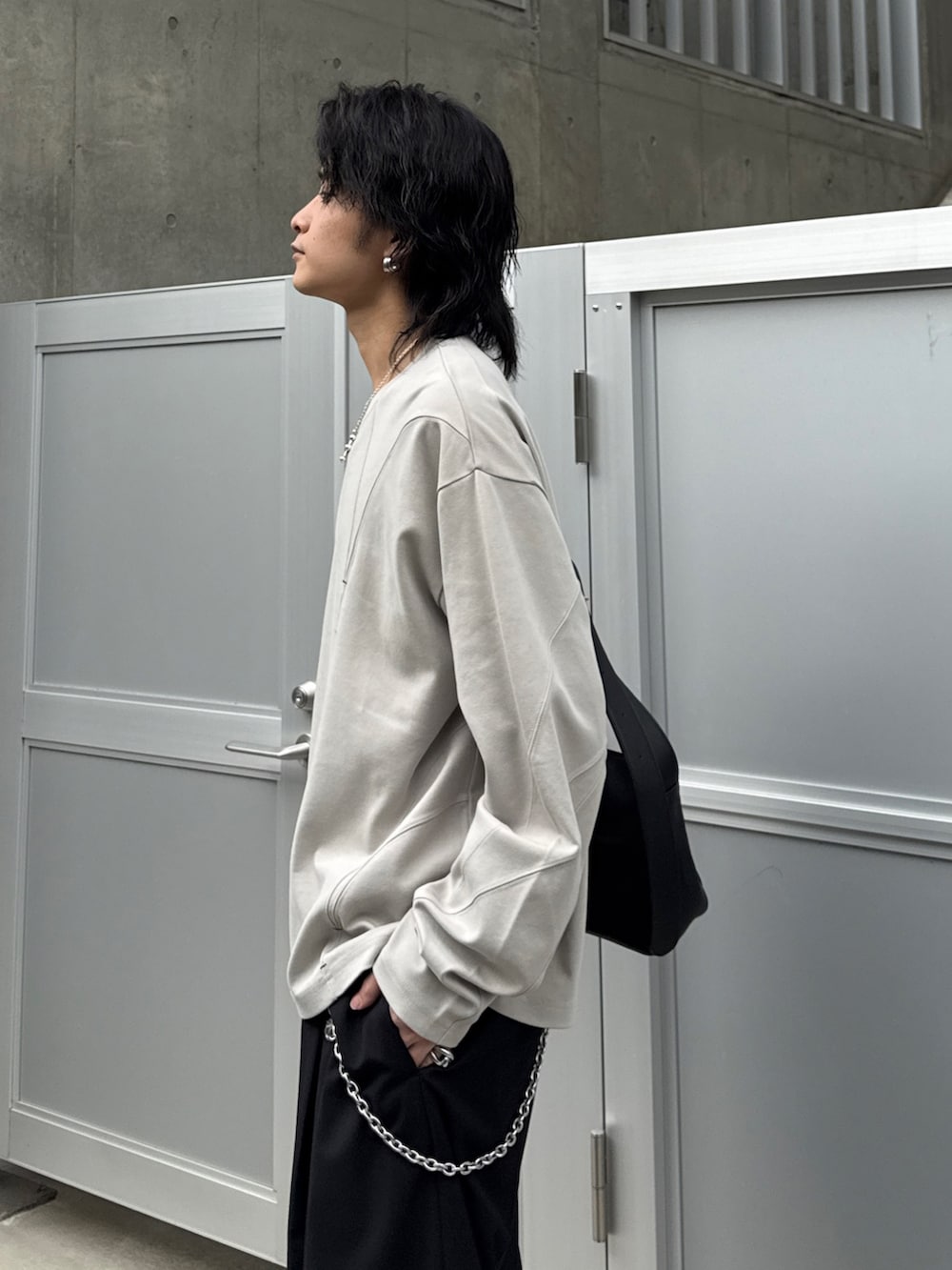 グレー系のTシャツ/カットソー、ブラック系のショルダーバッグ、ブラック系のスラックスを着用したメンズの春コーディネートの4枚目の写真