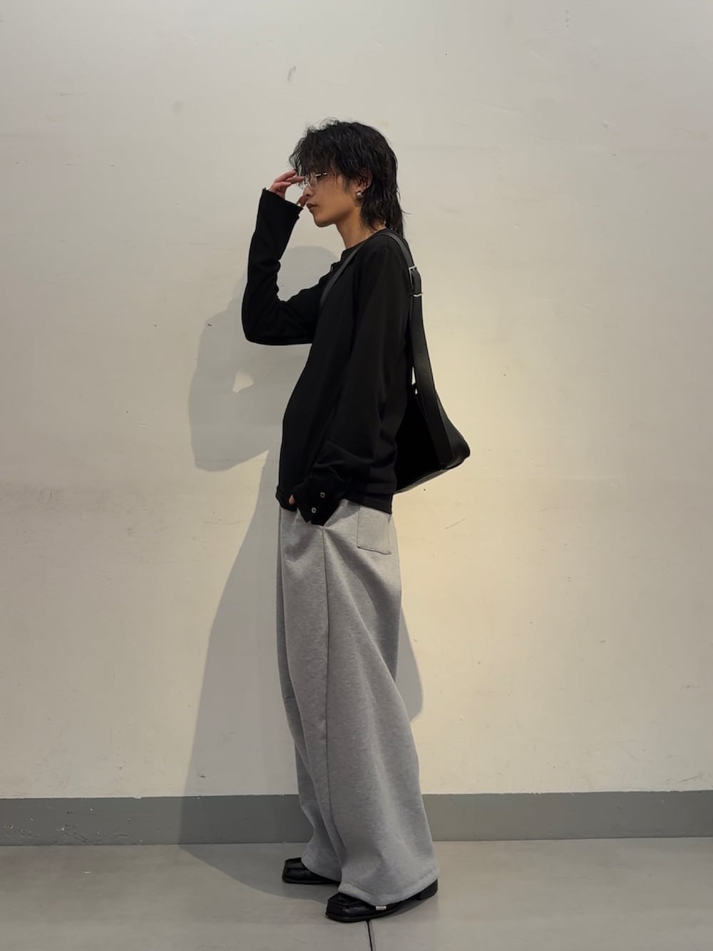 ブラック系のTシャツ/カットソー、グレー系のその他パンツ、ブラック系のショルダーバッグを着用したメンズの春コーディネートの3枚目の写真