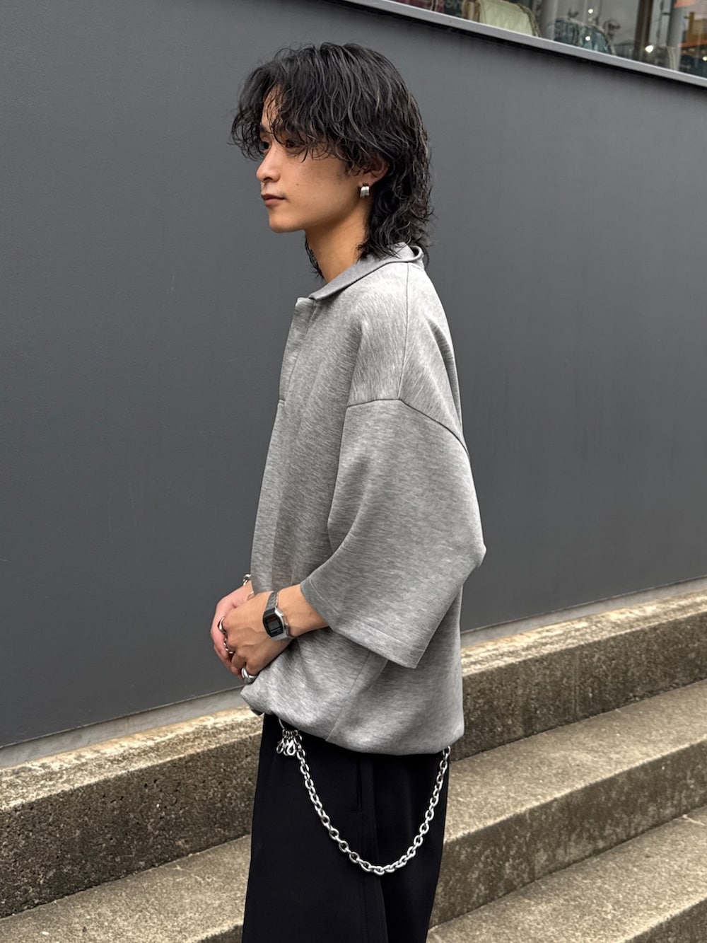 グレー系のTシャツ/カットソー、ブラック系のスラックス、シルバー系のウォレットチェーンを着用したメンズの夏コーディネートの5枚目の写真
