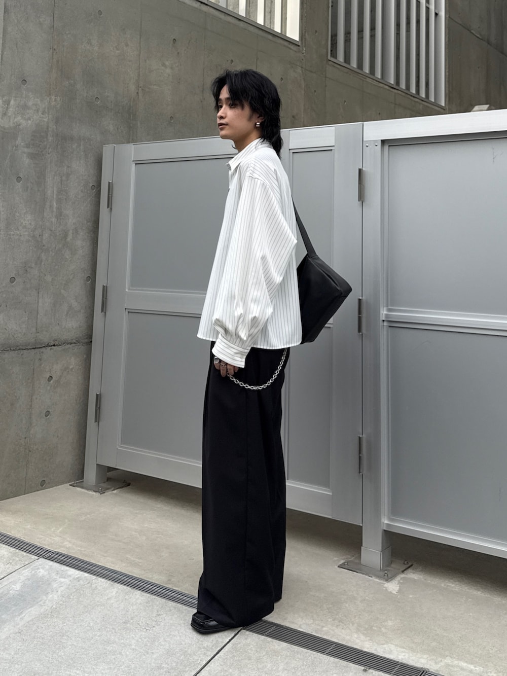 ホワイト系のシャツ/ブラウス、ブラック系のスラックス、ブラック系のショルダーバッグを着用したメンズの春コーディネートの2枚目の写真