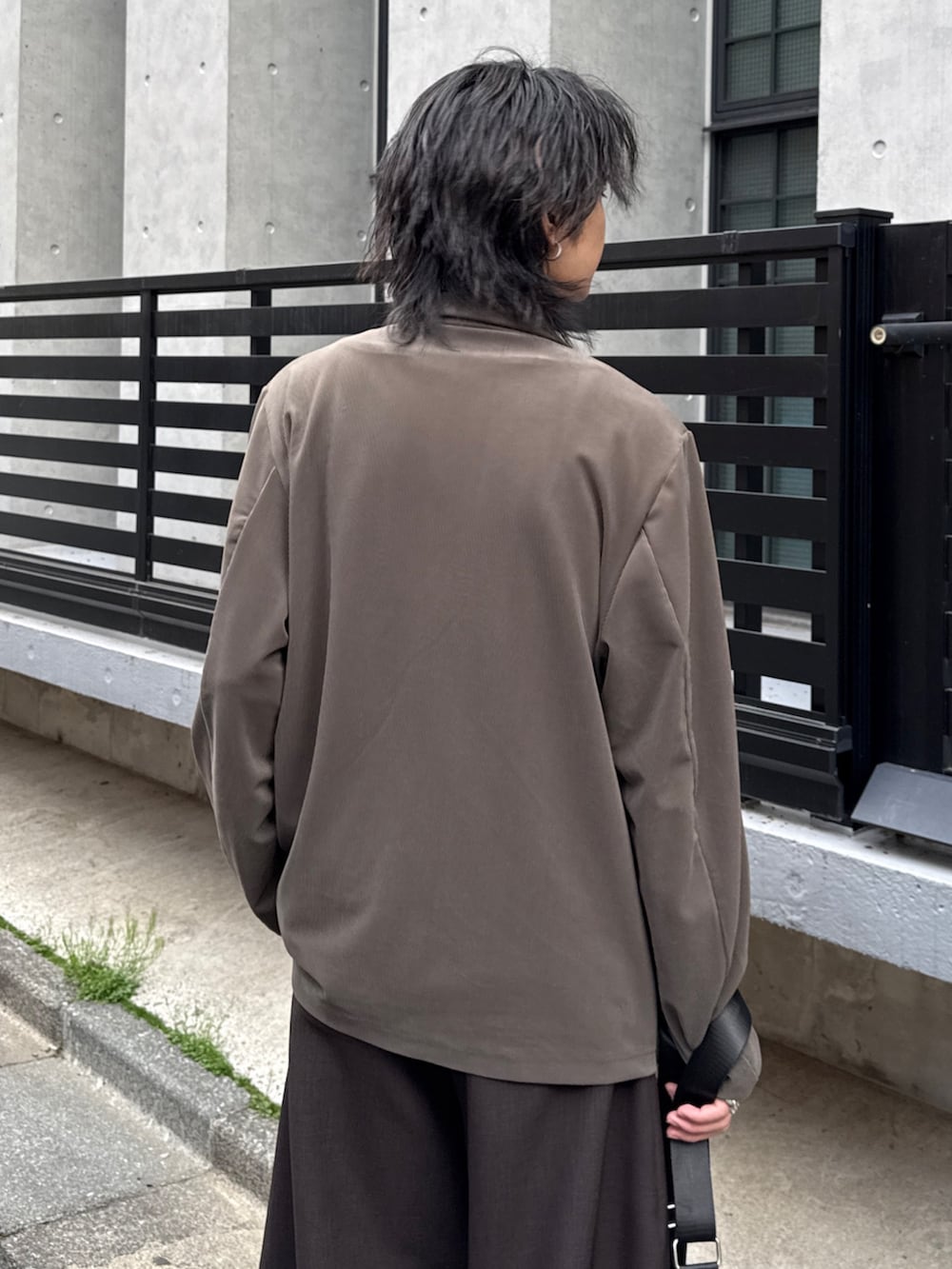 グレー系のTシャツ/カットソー、グレー系のスラックス、グリーン系のテーラードジャケットを着用したメンズの春コーディネートの6枚目の写真