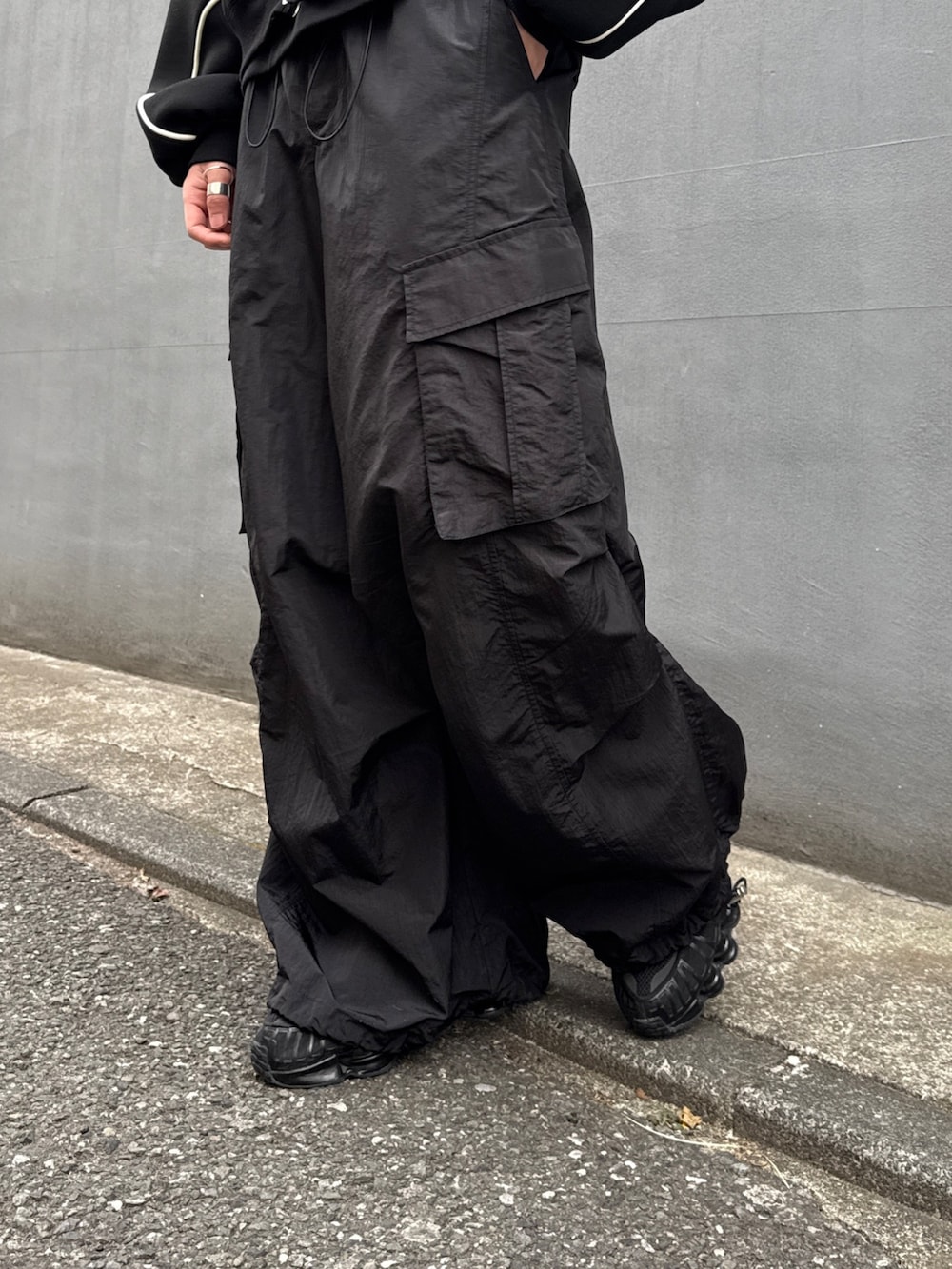 ブラック系のパーカー、ブラック系のカーゴパンツ、ブラック系のスウェットを着用したメンズの冬コーディネートの8枚目の写真