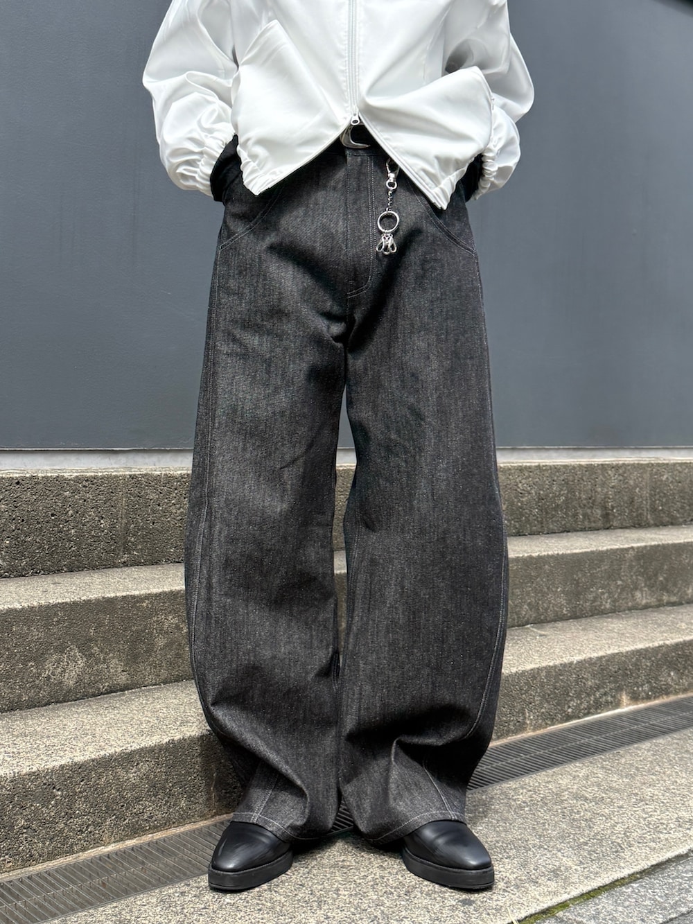 ホワイト系のブルゾン、ブラック系のTシャツ/カットソー、ブラック系のデニムパンツを着用したメンズの春コーディネートの8枚目の写真