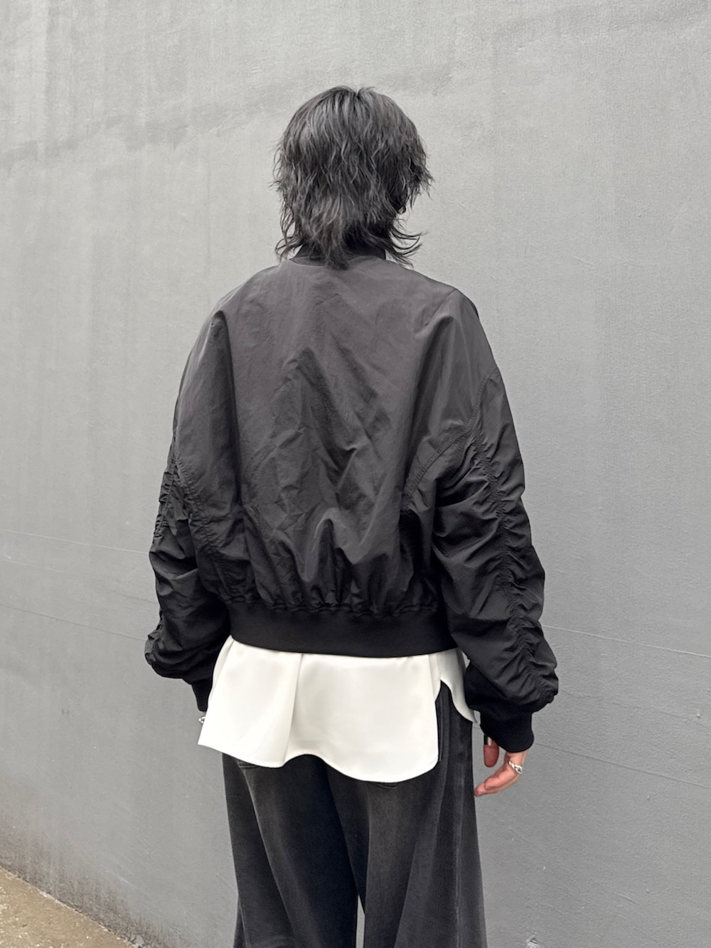 ブラック系のデニムパンツ、ホワイト系のシャツ/ブラウス、ブラック系のMA-1を着用したメンズの春コーディネートの6枚目の写真