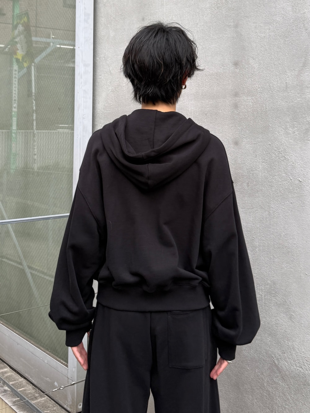 ブラック系のパーカー、ブラック系のスウェットパンツを着用したメンズの秋コーディネートの6枚目の写真
