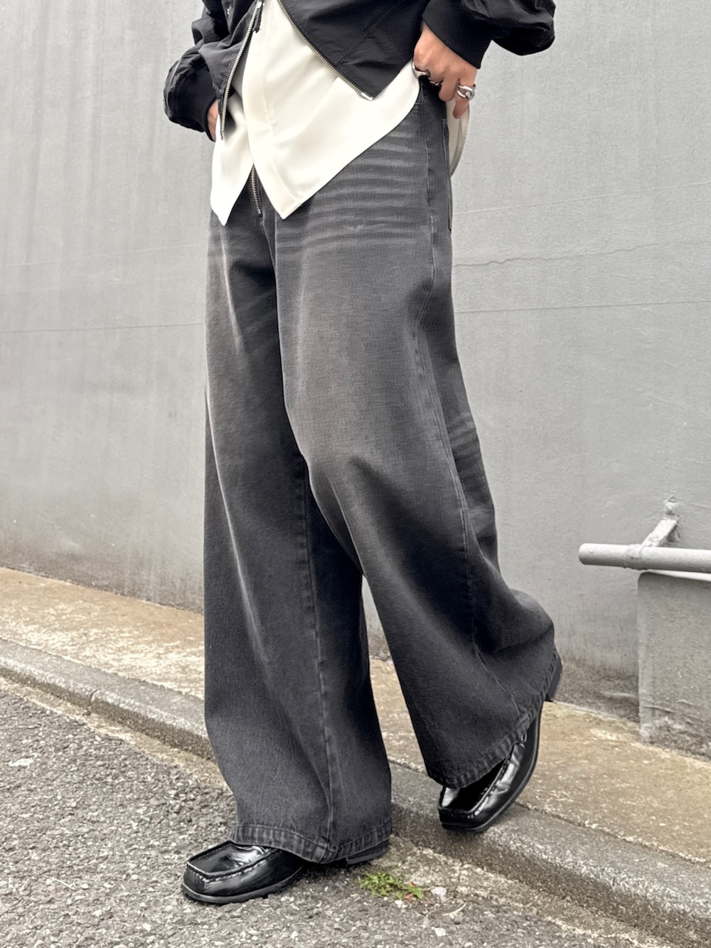 ブラック系のデニムパンツ、ホワイト系のシャツ/ブラウス、ブラック系のMA-1を着用したメンズの春コーディネートの8枚目の写真