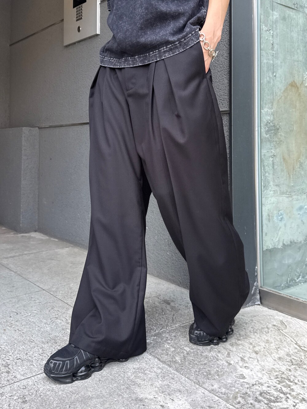 グレー系のTシャツ/カットソー、ブラック系のスラックスを着用したメンズの夏コーディネートの8枚目の写真