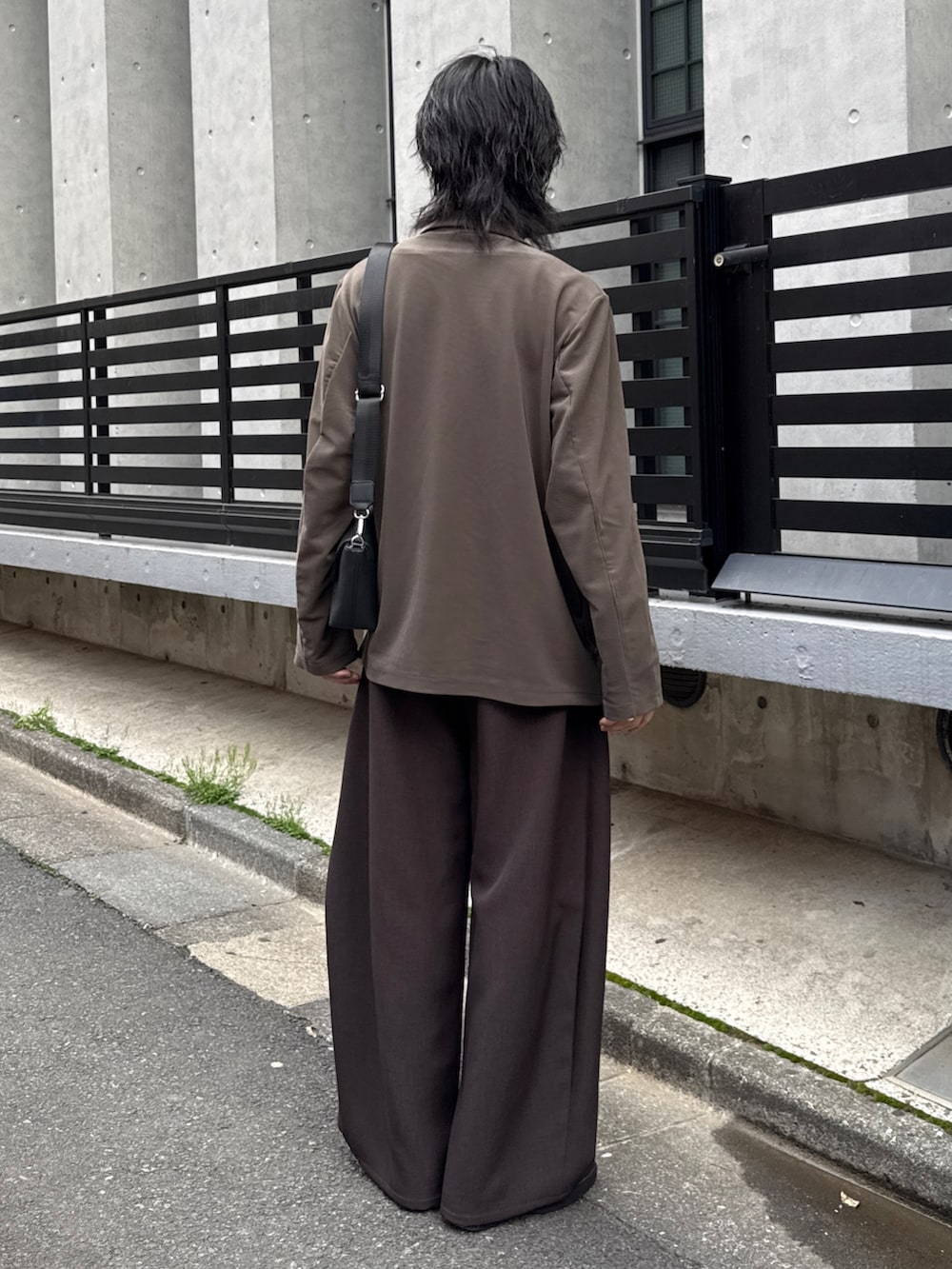 グレー系のTシャツ/カットソー、グレー系のスラックス、グリーン系のテーラードジャケットを着用したメンズの春コーディネートの3枚目の写真