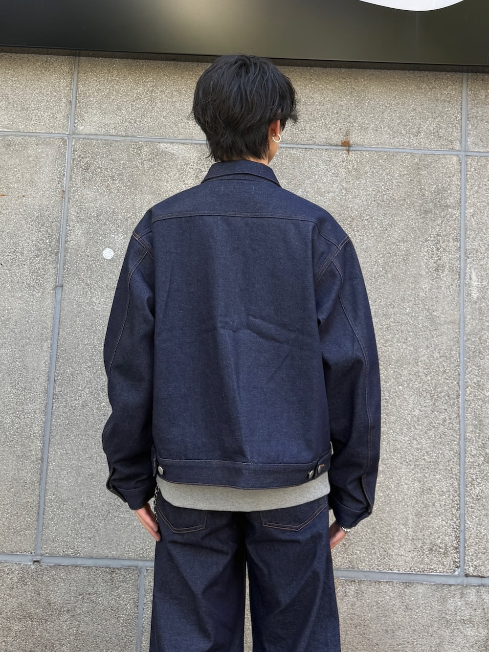 ブルー系のデニムジャケット、ブラック系のローファー、ブルー系のデニムパンツを着用したメンズの秋コーディネートの6枚目の写真