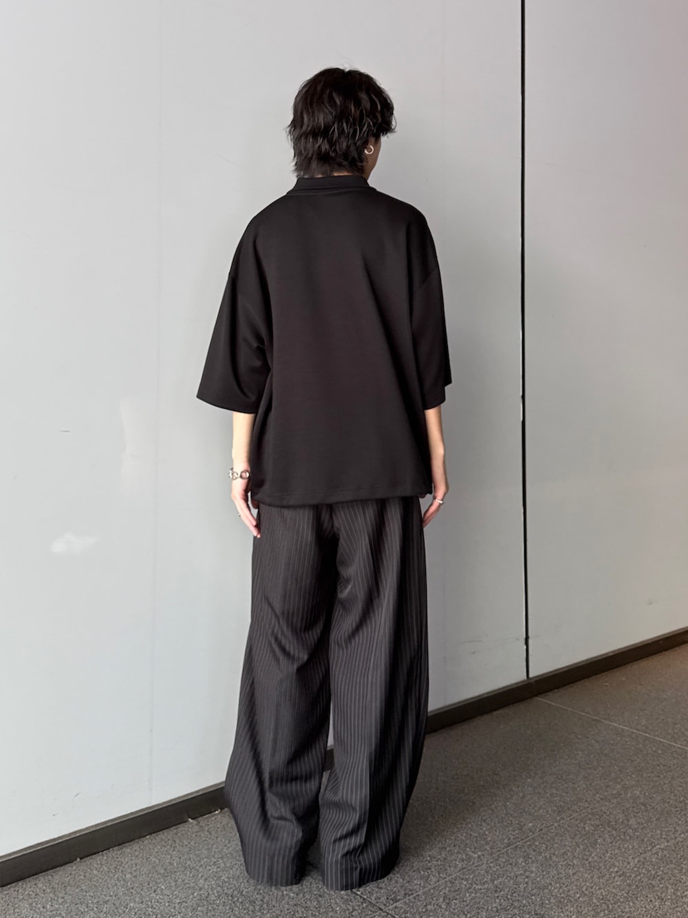 ブラック系のTシャツ/カットソー、グレー系のスラックスを着用したメンズの夏コーディネートの3枚目の写真