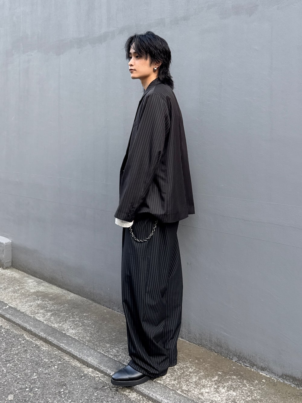 ブラック系のテーラードジャケット、ブラック系のスラックス、ホワイト系のTシャツ/カットソーを着用したメンズの春コーディネートの4枚目の写真