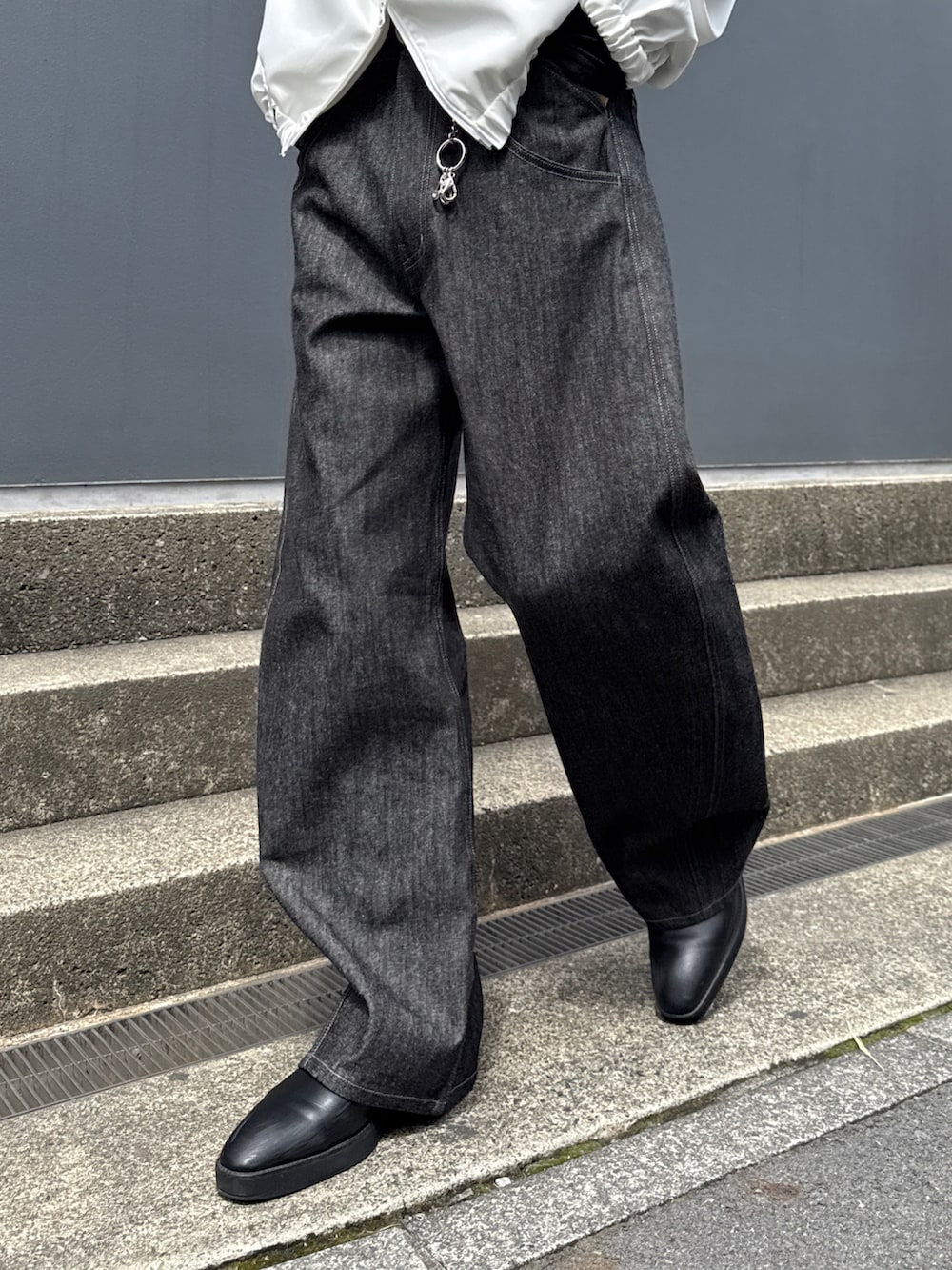 ホワイト系のブルゾン、ブラック系のTシャツ/カットソー、ブラック系のデニムパンツを着用したメンズの春コーディネートの9枚目の写真