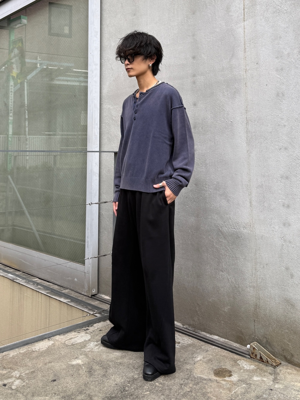 ブルー系のニット/セーター、ブラック系のスウェットパンツを着用したメンズの秋コーディネートの2枚目の写真