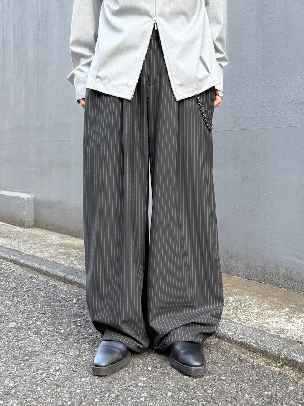 ブラック系のテーラードジャケット、グレー系のシャツ/ブラウス、ブラック系のスラックスを着用したメンズの春コーディネートの9枚目の写真