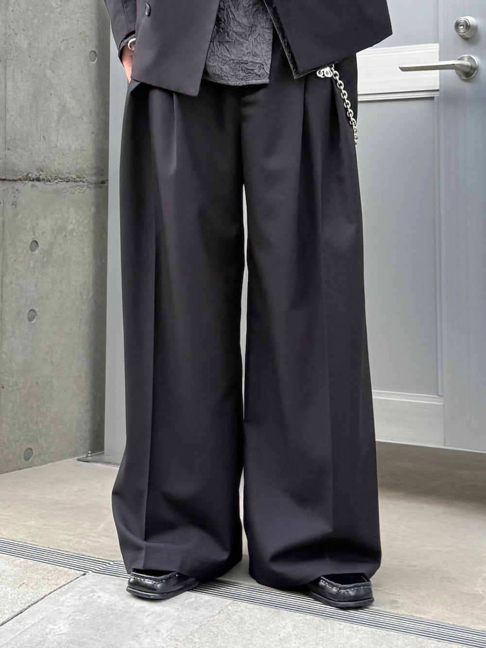 ブラック系のシャツ/ブラウス、ブラック系のスラックス、ブラック系のショルダーバッグを着用したメンズの春コーディネートの7枚目の写真